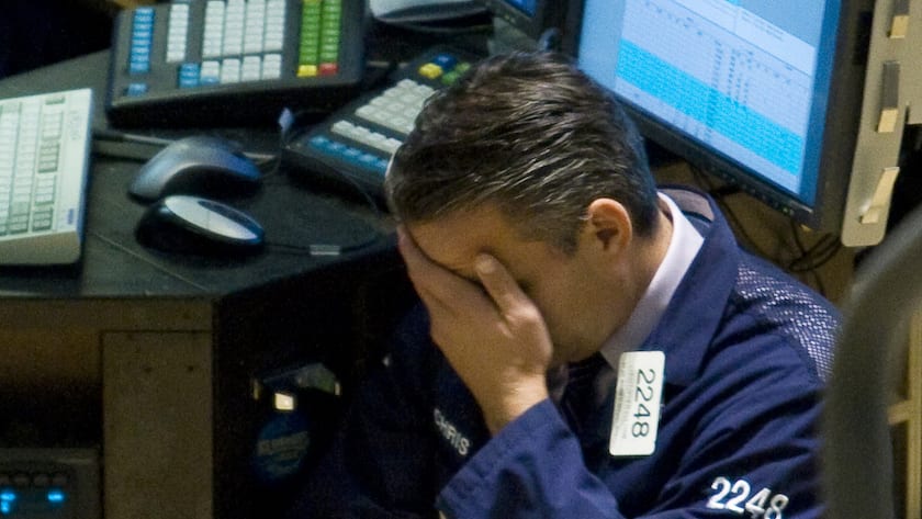 Ein Wall-Street-Händler reibt sich auf dem Parkett der New Yorker Börse nach einem schwierigen Handelsverlauf das Gesicht.